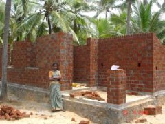 Mariamal in front of her house under construction